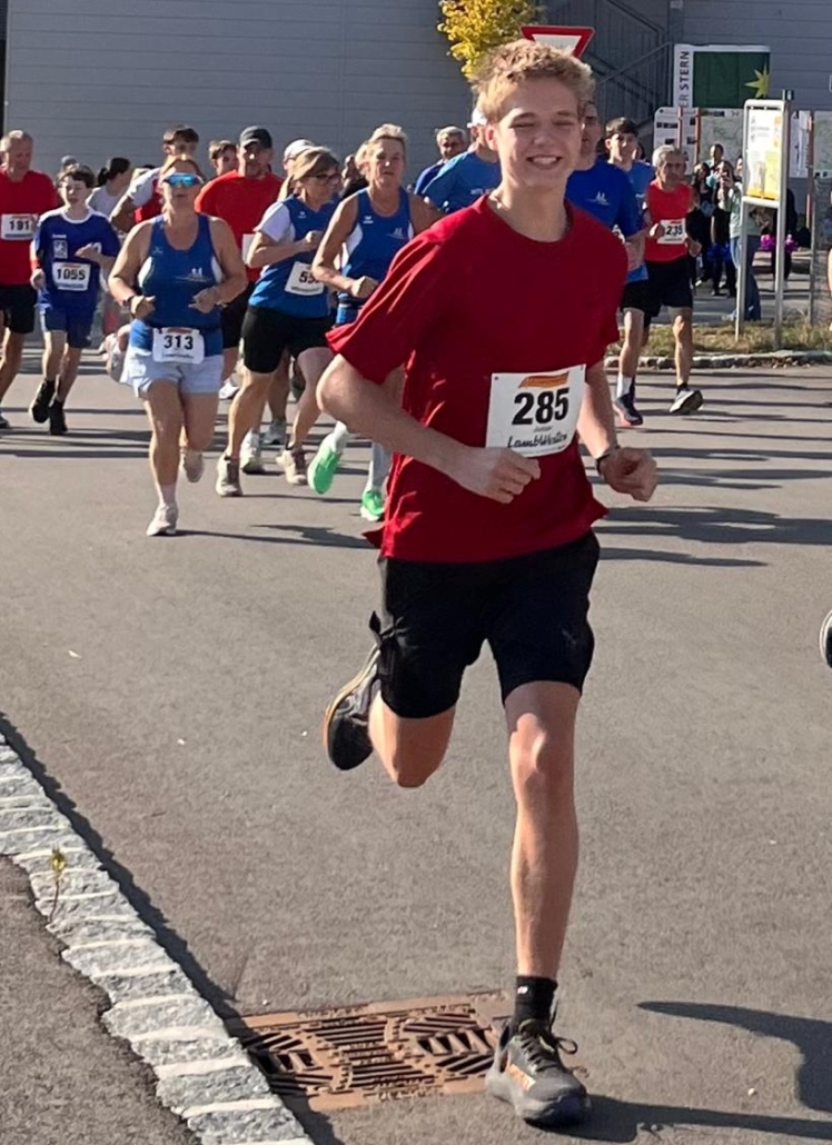 Läufer mit Startnummer 285 im roten Trikot bei einem Lauf in Lambach